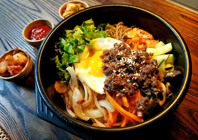 大学生在学校食堂打饭，餐盘里有米饭蔬菜和肉类，食堂环境整洁明亮，营养均衡的一餐